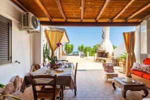 a patio with a table and chairs and a couch at Vistamare2 in Cardedu