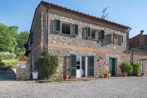 an old stone building with green shutters on it at Emma e Adele House in Marlia
