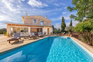 a villa with a swimming pool in front of a house at Finca Som Llum in Palma de Mallorca