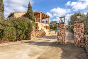 a house with a gate and a stone fence at Finca Som Llum in Palma de Mallorca