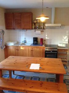 a kitchen with a wooden table in the middle at Gîte du Poney Fringant in Saint-Paul-Trois-Châteaux