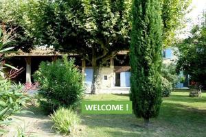 a sign in front of a house with a tree at Gîte du Poney Fringant in Saint-Paul-Trois-Châteaux