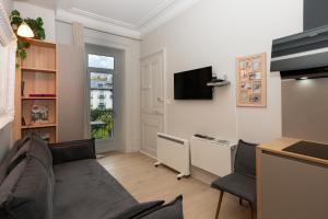 a living room with a couch and a tv at Au Temps Suspendu in Aix-les-Bains
