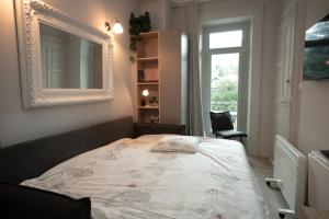 a bedroom with a bed with a mirror and a window at Au Temps Suspendu in Aix-les-Bains +19 photos