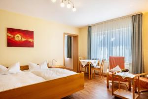 a hotel room with a bed and a dining room at Haus Gramespacher in Bad Bellingen