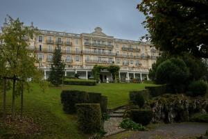 a large building with a garden in front of it at Au Temps Suspendu in Aix-les-Bains