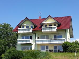 a house with a red roof and white balconies at Landhaus Erben in Wasserburg