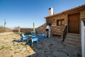 a patio with a table and chairs in front of a building at Casa Rural Jaraiz Vip in Laroya