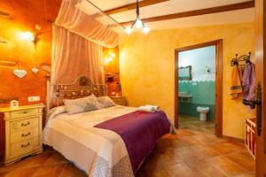 a bedroom with a bed and a bathroom at Casa Rural Jaraiz Vip in Laroya +20 photos
