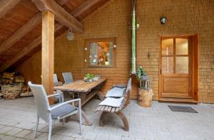 a patio with a wooden table and chairs and a door at Landhaus Dachsberg in Wittenschwand