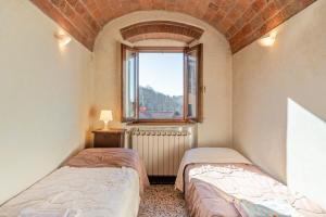 two beds in a small room with a window at Casa Claire in Prataccio