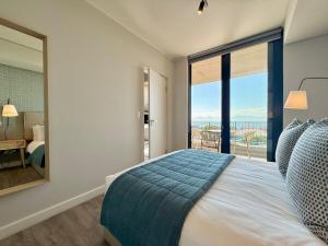 a bedroom with a bed and a large window at Indigo Tide - Mossel Cove Unit 201 in Mossel Bay +25 photos