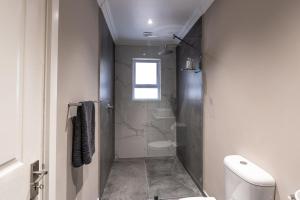 a bathroom with a shower and a toilet in it at The Palm Suites in Meadowridge +11 photos