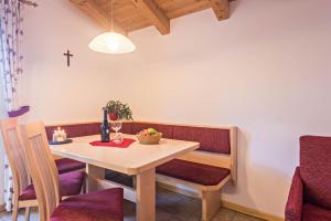 a dining room with a table and a cross on the wall at Schildberghof Ortler in Kastelruth