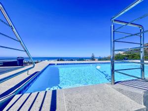 a swimming pool with a view of the ocean at Indigo Tide - Mossel Cove Unit 201 in Mossel Bay
