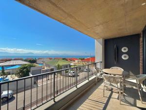 a balcony with a table and chairs and a view at Indigo Tide - Mossel Cove Unit 201 in Mossel Bay