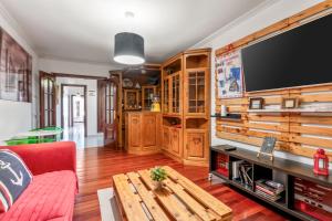 a living room with a table and a large tv at O Faro Apartamentos in Ribadeo +16 photos