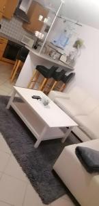 a white coffee table with two black chairs on a rug at Wohnung mit Terasse im Schwarzwald in Seebach