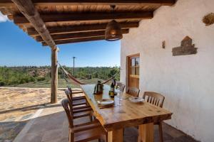 a wooden table and chairs on a patio with a view at Casa Moinho Da Eira in Loulé