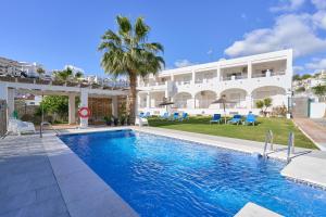 a swimming pool in front of a building at Nerja Vacaciones Apartamentos in Nerja