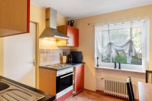 a small kitchen with a stove and a window at Ferienwohnung Carolin in Dornstetten