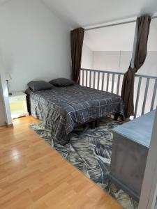 a bed in a room with a rug on the floor at L'échoppe Rochelaise in La Rochelle