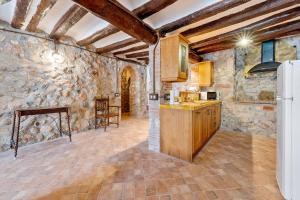 a kitchen with stone walls and a refrigerator at Casa Encanto con Jacuzzi in Montroig