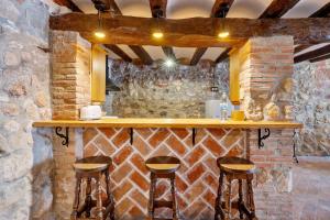 a bar with wooden stools in a stone wall at Casa Encanto con Jacuzzi in Montroig +13 photos