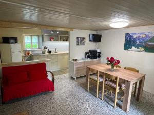 a living room with a table and a red couch at La Casa di Sissy in Trasquera