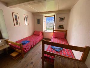 a room with two beds and a window at La Casa di Sissy in Trasquera