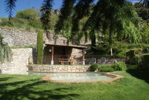 a stone house with a small pool in a yard at El Racó d'Espunyes in Oden