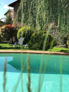 a swimming pool with a chair and a table at El Racó d'Espunyes in Oden