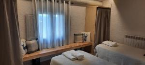 a bedroom with two twin beds and a window at El Racó d'Espunyes in Oden