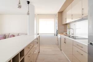 a kitchen with white cabinets and a white counter top at Surf and Chill House in Viana do Castelo