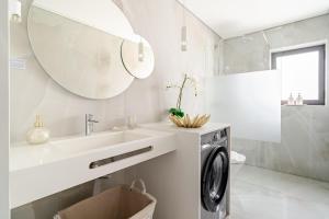 a bathroom with a sink and a washing machine at Surf and Chill House in Viana do Castelo
