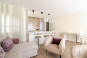 a living room with a couch and chairs and a kitchen at Surf and Chill House in Viana do Castelo +14 photos