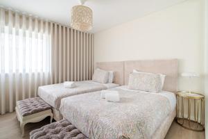 a bedroom with two beds and a chair at Surf and Chill House in Viana do Castelo