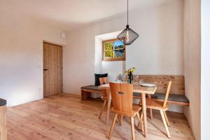 a dining room with a wooden table and chairs at Hof im Thal Apt Lärche in Aldino