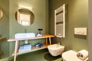 a bathroom with a sink and a mirror and a toilet at Hof im Thal Apt Lärche in Aldino
