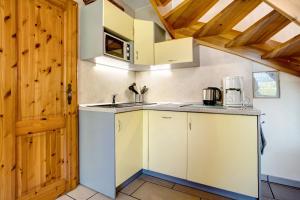 a kitchen with white cabinets and a wooden door at Fewo 14 - Halbinsel Darss - Ostsee in Wieck