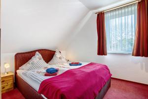 a bedroom with a bed with pink sheets and a window at Fewo 14 - Halbinsel Darss - Ostsee in Wieck