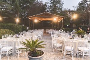 a wedding reception with white tables and chairs and lights at Lavanda ad Antico Casale '700 in Umbertide