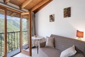 a living room with a couch and a large window at U Graie in Apricale