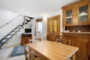 a dining room with a wooden table and a staircase at U Graie in Apricale
