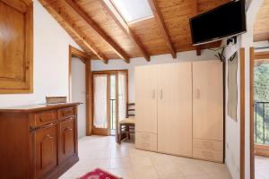 a kitchen with white cabinets and a flat screen tv at U Graie in Apricale