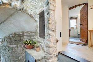 a stone wall with a window and two potted plants at U Graie in Apricale
