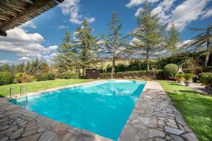 a swimming pool with blue water in a yard at Lavanda ad Antico Casale '700 in Umbertide
