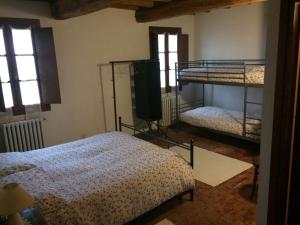 a bedroom with two bunk beds and a television at Agriturismo La Rovere in Cesole