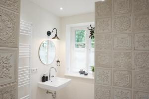 a white bathroom with a sink and a mirror at Der Mühlenhof in Högel +51 photos