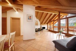 a large living room with wooden ceilings and windows at Stettnerhof Wohnung Penegal in Vollan